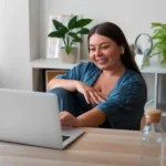 Profesional en su escritorio en casa, con elementos laborales y personales.