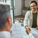 Reclutador y candidato frente a frente en una oficina o videollamada.